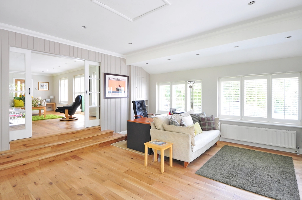 Salon propre et lumineux avec parquet et canapé blanc